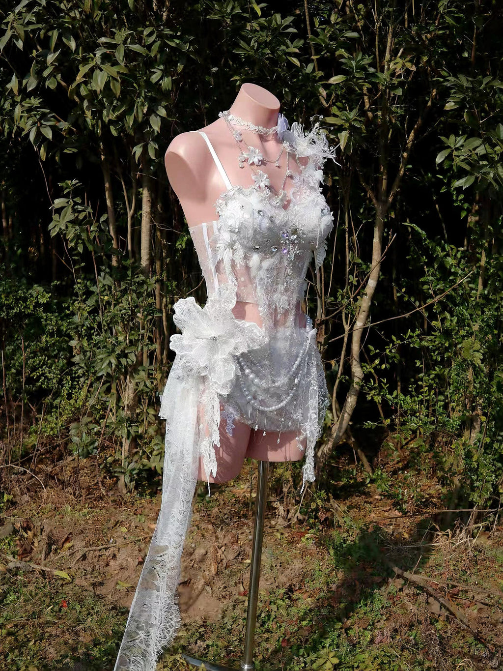 AVRY Elowen lace corset RAVE fairy set featuring embroidered lace corset, draped lace skirt, floral feather shoulder brooch and layered necklaces.